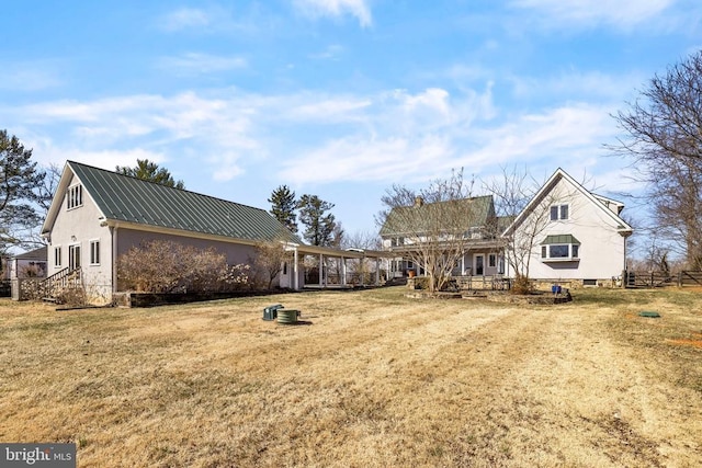 view of front of property featuring fence, metal roof, and a front yard