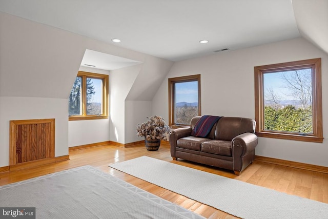 additional living space with visible vents, vaulted ceiling, baseboards, and wood finished floors