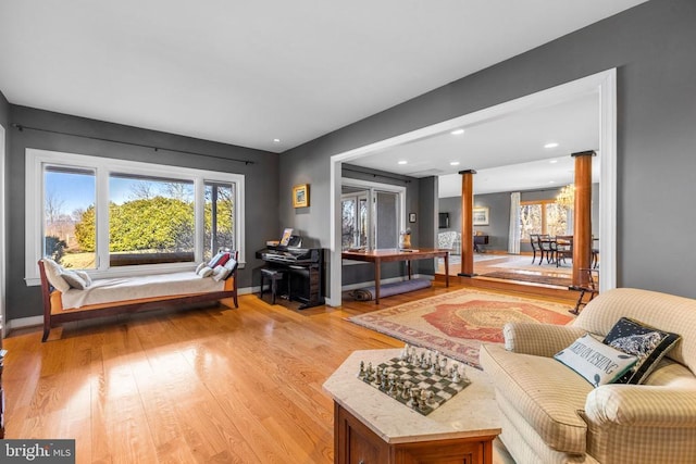 living area with light wood-type flooring, ornate columns, baseboards, and recessed lighting