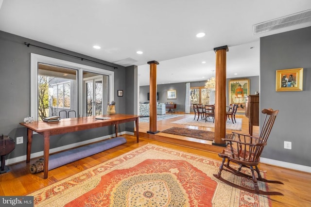 office space featuring recessed lighting, wood finished floors, visible vents, baseboards, and ornate columns