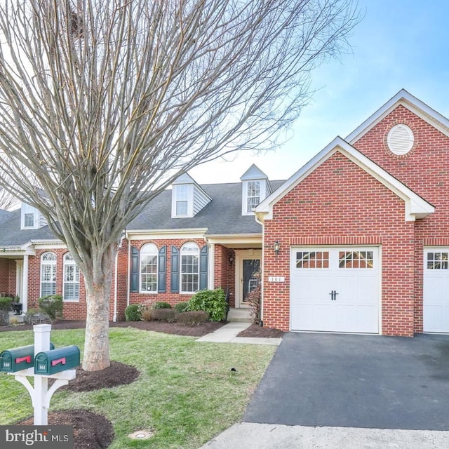 view of front of home featuring an attached garage, a shingled roof, a front lawn, aphalt driveway, and brick siding