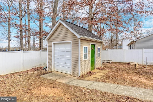 detached garage with fence and driveway