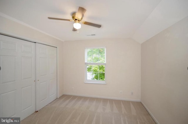 unfurnished bedroom featuring a closet, light carpet, visible vents, and baseboards