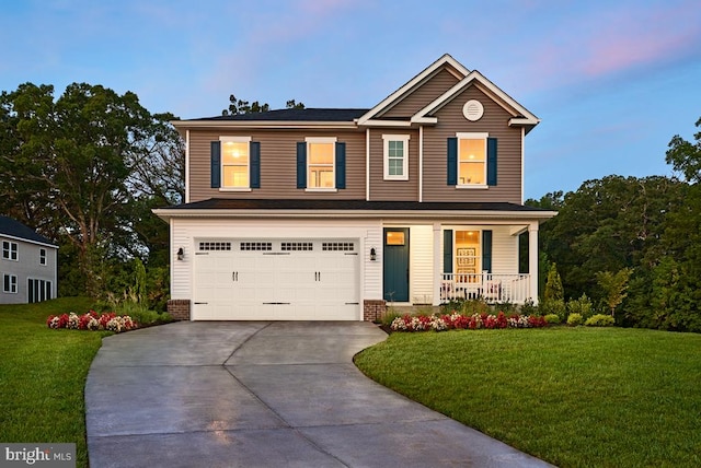 view of front of home featuring a garage, a lawn, and a porch