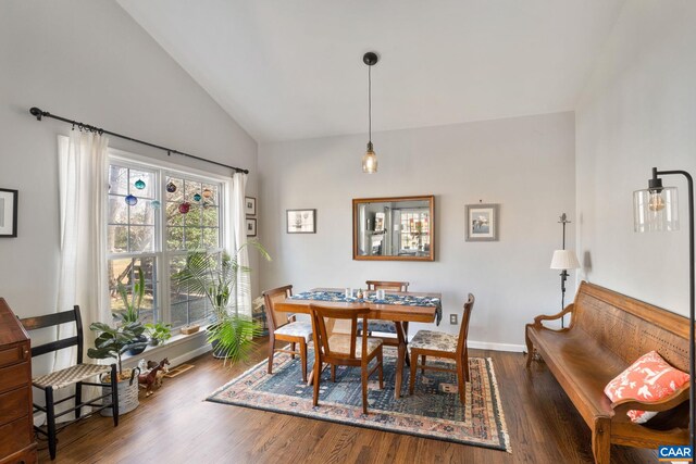 dining space with vaulted ceiling, wood finished floors, and baseboards