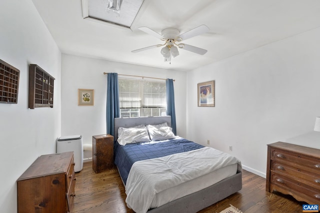 bedroom with ceiling fan, attic access, baseboards, and wood finished floors