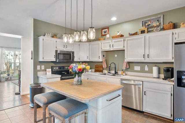 kitchen featuring a sink, white cabinetry, appliances with stainless steel finishes, light countertops, and light tile patterned floors