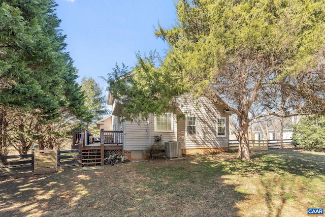 exterior space with fence private yard, a lawn, central AC, and a wooden deck