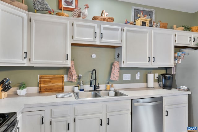 kitchen with a sink, stainless steel appliances, white cabinetry, and light countertops