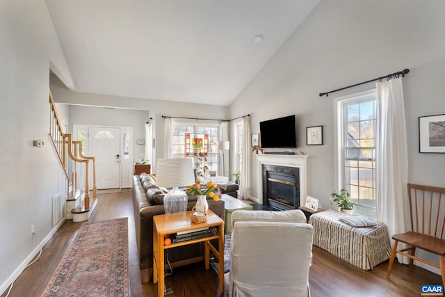 living area featuring a wealth of natural light, stairway, a premium fireplace, and wood finished floors