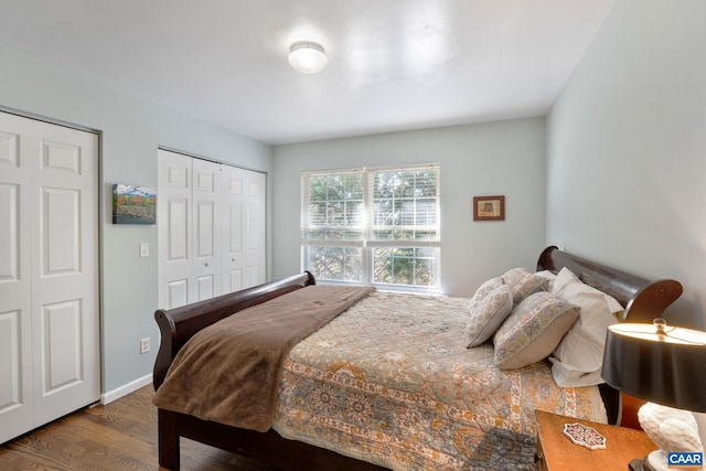 bedroom with wood finished floors, baseboards, and a closet