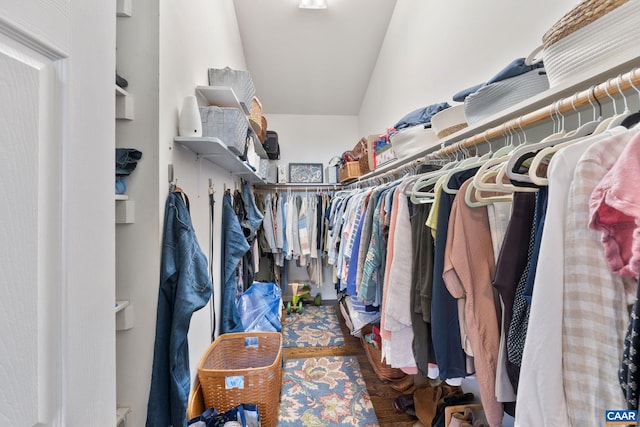 walk in closet with lofted ceiling and wood finished floors