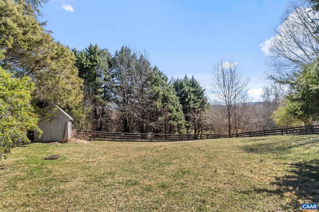 view of yard with a storage unit, an outbuilding, and fence