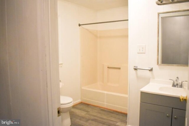 full bathroom with hardwood / wood-style flooring, vanity, toilet, and shower / bathing tub combination