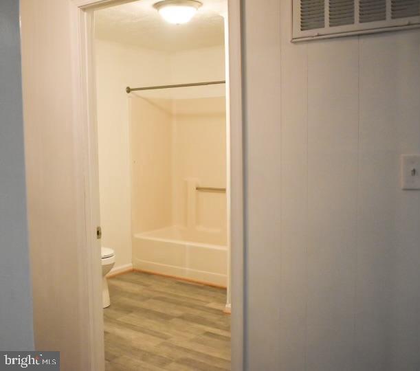 bathroom featuring wood-type flooring and toilet