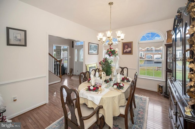 dining area with dark wood-type flooring and a notable chandelier