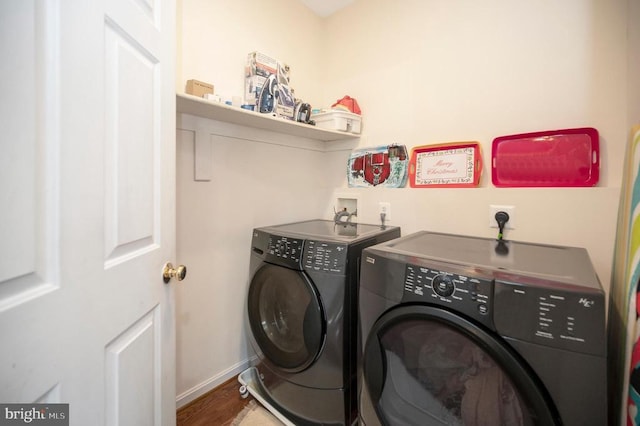 laundry room featuring wood-type flooring and separate washer and dryer