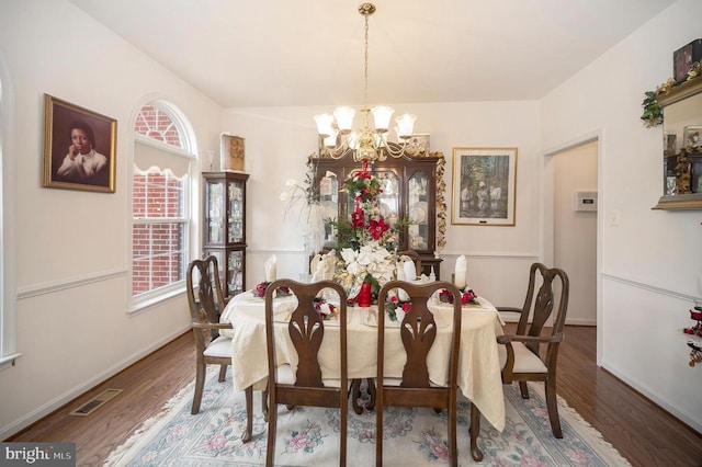 dining area featuring dark hardwood / wood-style flooring and a chandelier