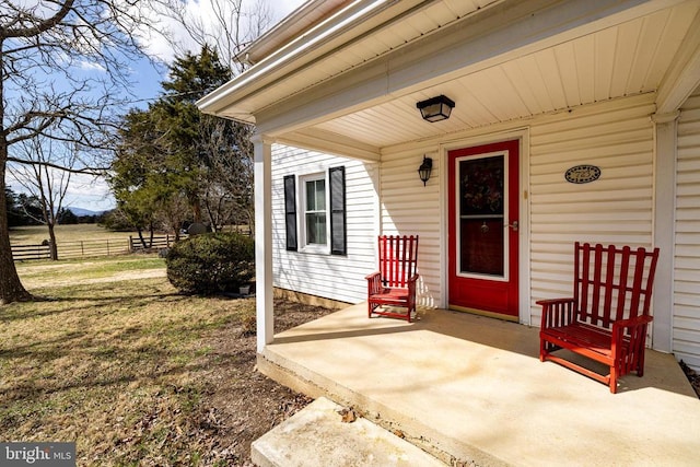 property entrance featuring a lawn and fence