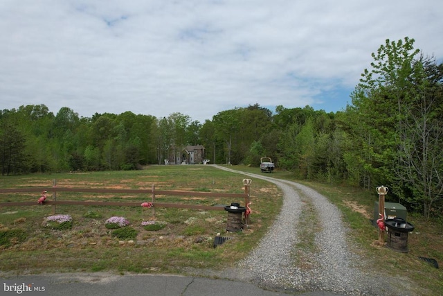 view of street featuring a wooded view and driveway