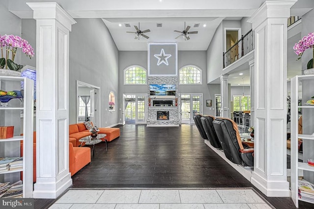 living room featuring wood finished floors, decorative columns, and a ceiling fan