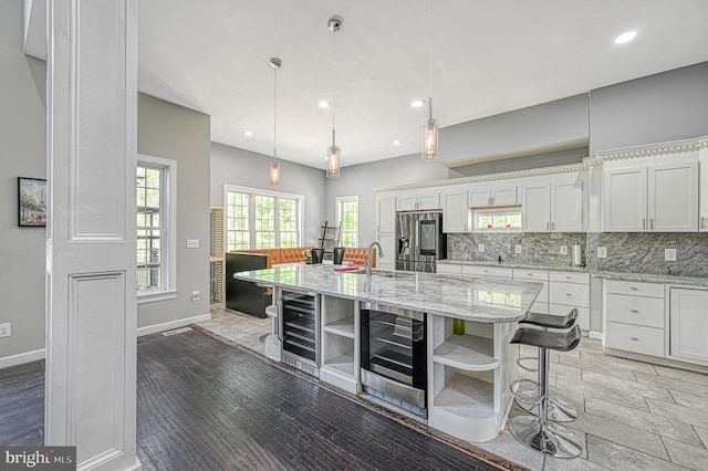 kitchen featuring decorative backsplash, stainless steel fridge, white cabinets, and open shelves