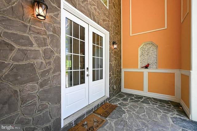 entrance to property featuring french doors and stone siding