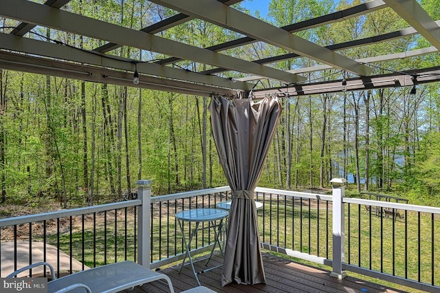 wooden terrace featuring a forest view and a pergola