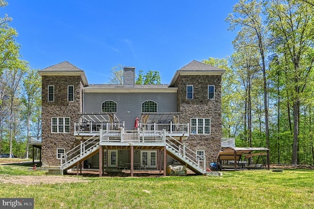 back of house with stairs, a deck, a lawn, and a chimney