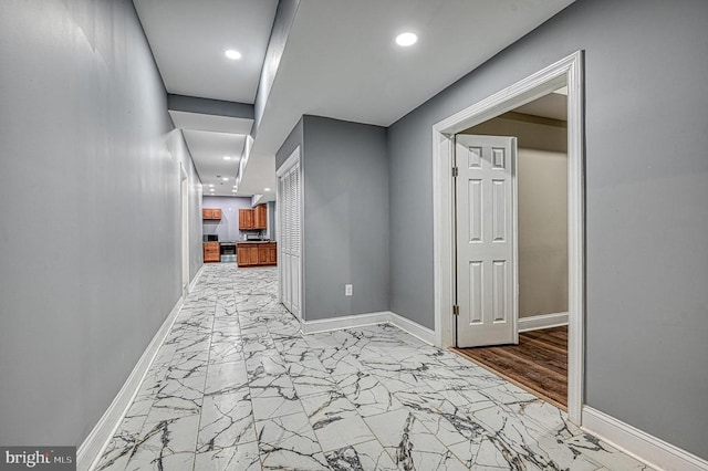 hallway with recessed lighting, baseboards, and marble finish floor