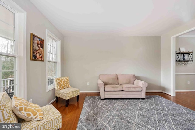 living area with baseboards and wood finished floors