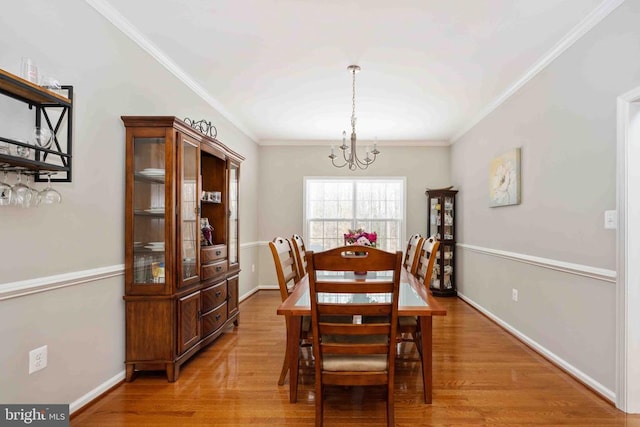 dining room featuring light wood-type flooring, baseboards, and ornamental molding