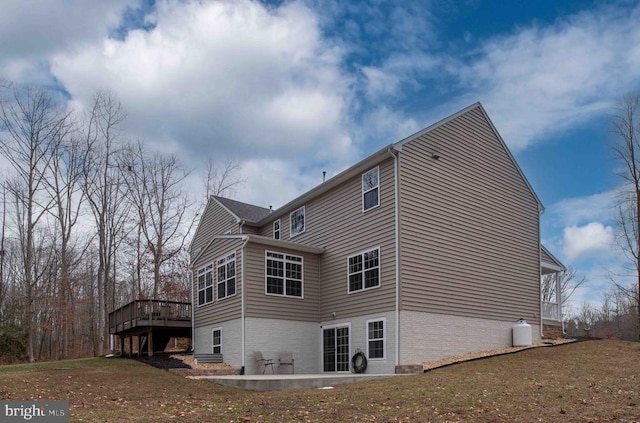 view of side of property featuring a deck and brick siding