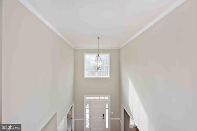 foyer featuring a notable chandelier and crown molding