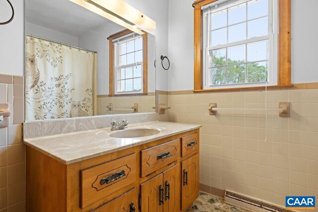 bathroom with vanity, tile walls, wainscoting, and a shower with shower curtain