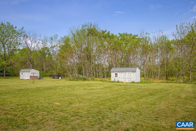 view of yard featuring a storage shed and an outbuilding