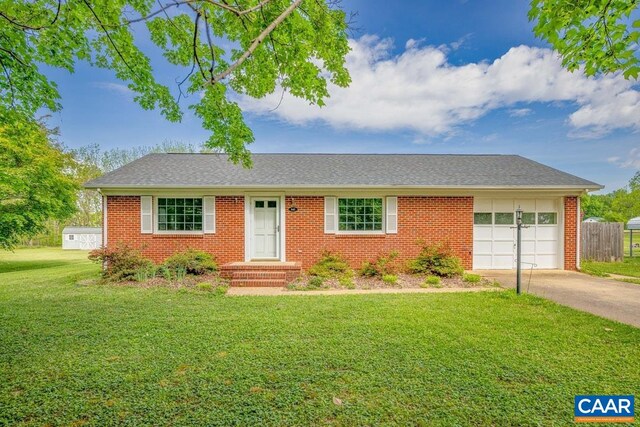 ranch-style house featuring roof with shingles, an attached garage, a front lawn, brick siding, and driveway