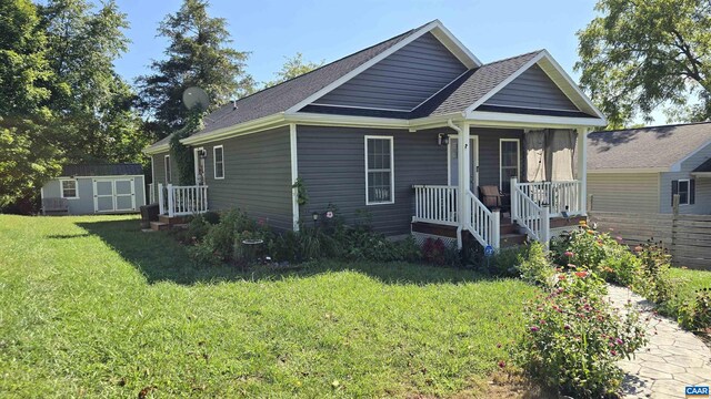 view of front of house with a front yard and a storage shed