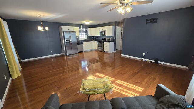 living room featuring dark hardwood / wood-style floors and ceiling fan with notable chandelier