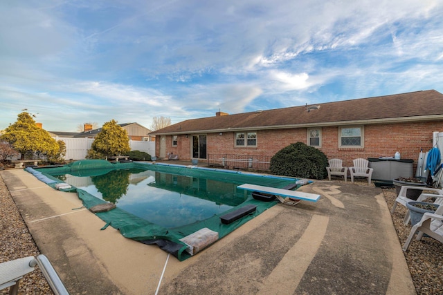 view of pool with a hot tub, a patio, and a diving board