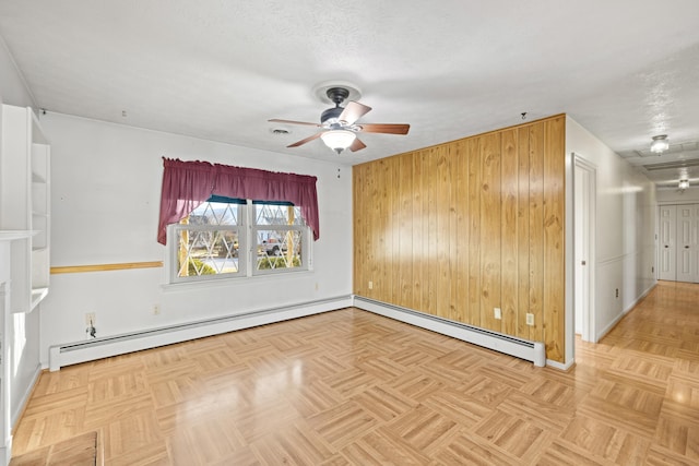 unfurnished room featuring a baseboard heating unit, a textured ceiling, and light parquet floors