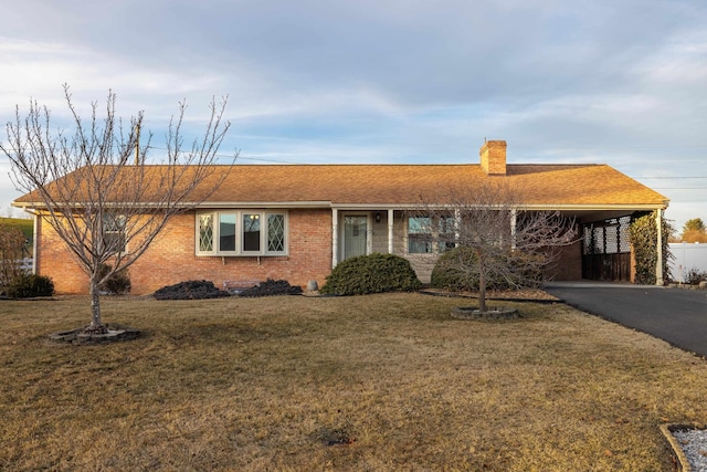 ranch-style house with a carport and a front lawn