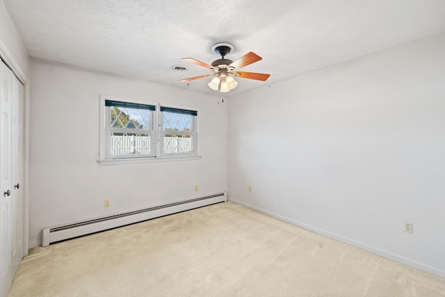 unfurnished bedroom with light carpet, a closet, a textured ceiling, and baseboard heating