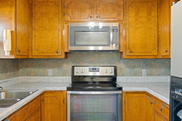 kitchen featuring appliances with stainless steel finishes, sink, and backsplash