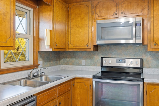 kitchen featuring appliances with stainless steel finishes, sink, and backsplash