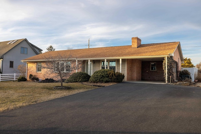 ranch-style home with a carport and a front lawn