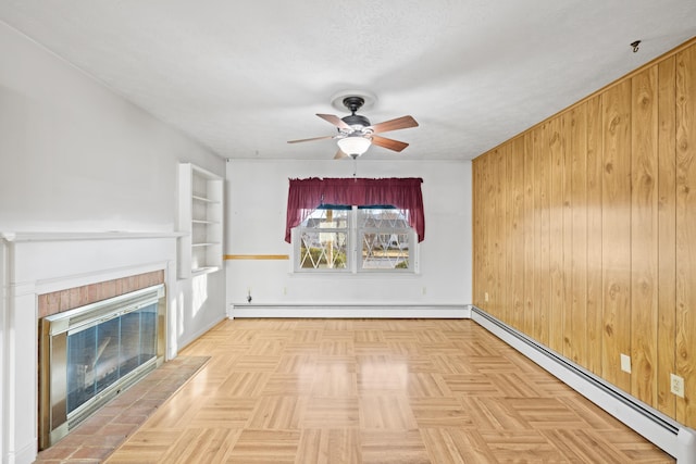 unfurnished living room with parquet flooring, ceiling fan, a textured ceiling, and a baseboard heating unit