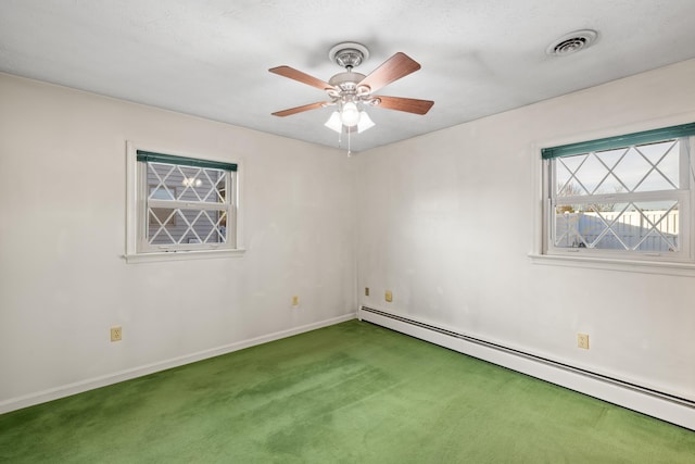 carpeted spare room featuring a baseboard heating unit and ceiling fan