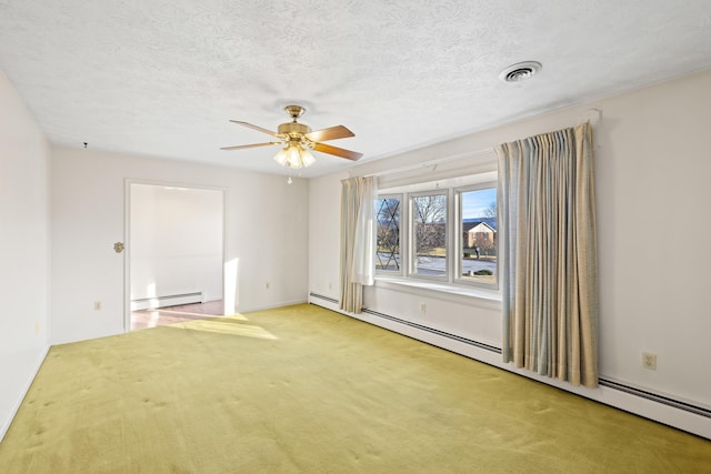 carpeted empty room featuring ceiling fan, a textured ceiling, and a baseboard heating unit