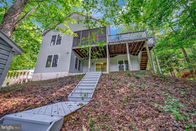 view of front property with a wooden deck and a sunroom